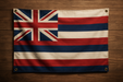 Realistic looking Hawaii flag with brass grommets in all 4 corners mounted on a wood wall