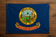 Realistic looking Idaho flag with brass grommets in all 4 corners mounted to a wood wall