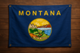 Realistic Montana flag with brass grommets in each corner mounted to a wood wall