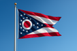 Realistic Ohio flag flying on a flagpole with clear blue sunny skies